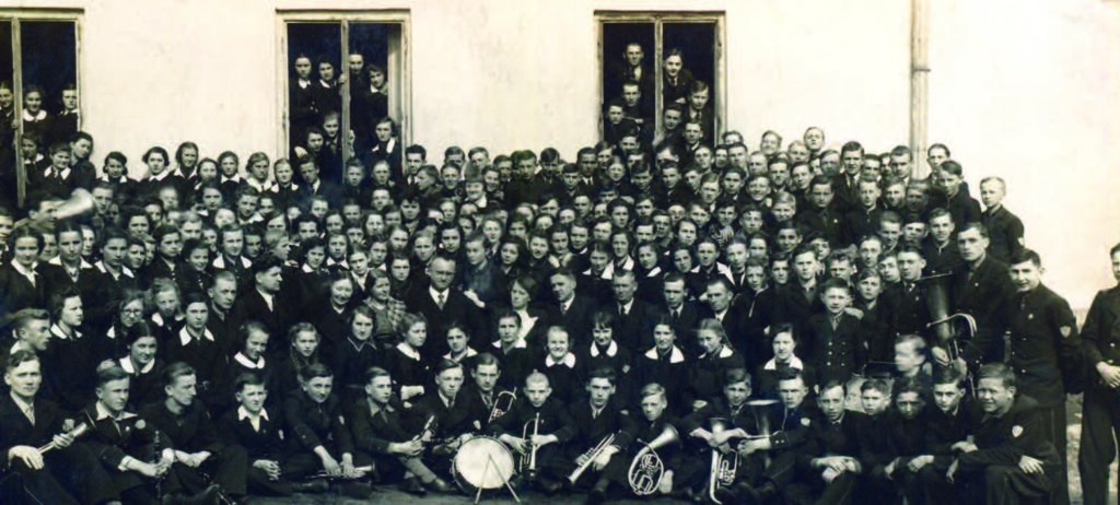 Uczniowie na dziedzińcu szkoły. Pośrodku grupy młodzieży siedzi dyrektor Cezak - maj 1938